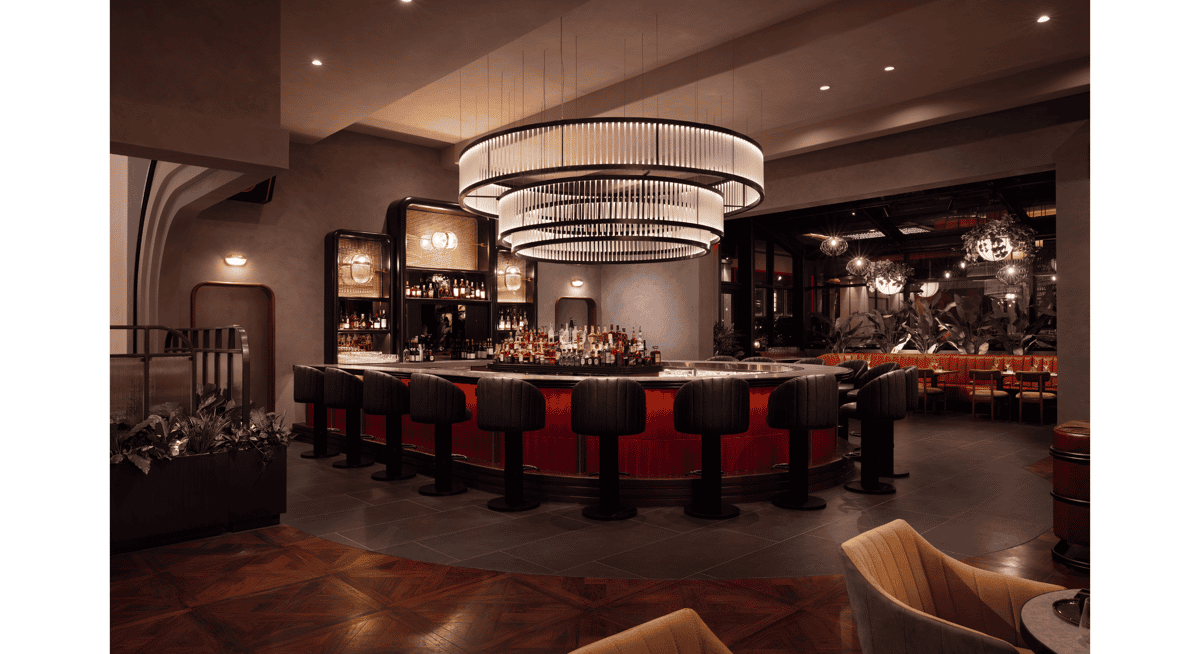 Upscale restaurant bar with modern chandelier lighting, red illuminated bar counter, and luxury cocktail seating