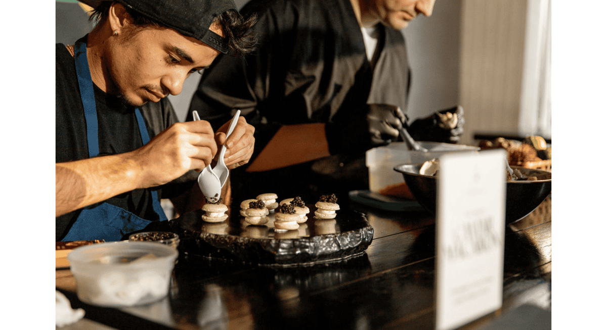 Chef carefully plating gourmet bite-sized appetizers topped with caviar in a high-end Miami restaurant kitchen, showcasing precision and culinary artistry.