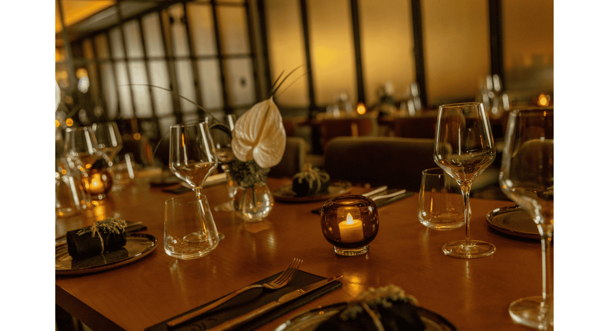 Candlelit fine dining table setting with wine glasses and floral centerpiece in an intimate Las Vegas restaurant.