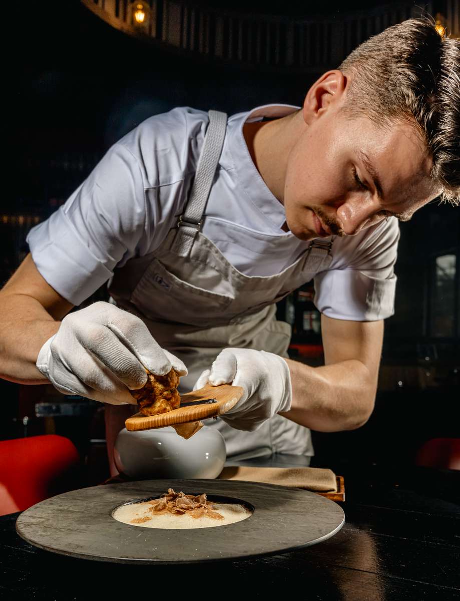 Chef carefully plating a gourmet dish during a fine dining service in Miami.