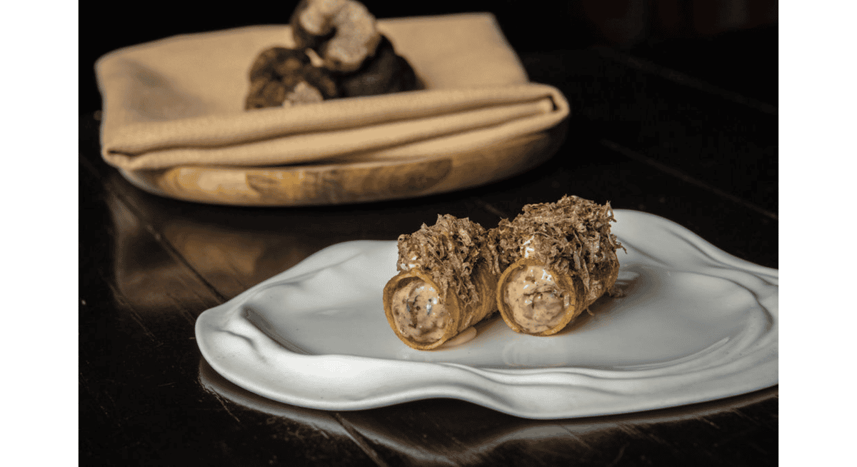 Two crispy cannoli filled with creamy savory mousse and topped with shaved truffle, plated elegantly at Stubborn Seed in Miami.