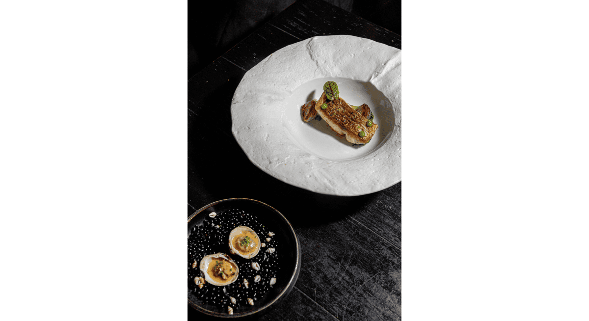Chef's tasting menu course featuring delicately plated seafood and seasonal ingredients in a refined Michelin-style presentation.