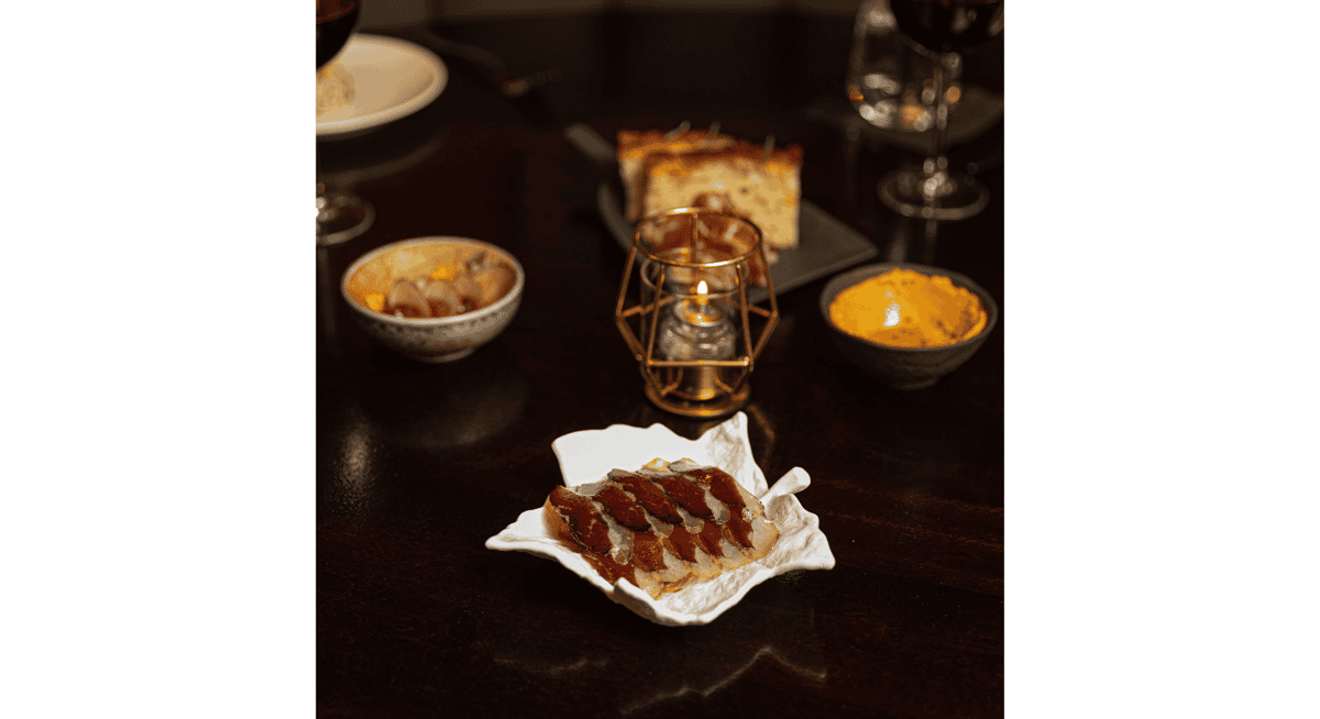 Artfully plated gourmet course served on an elegant dish with wine and candlelight, highlighting the immersive experience of a creative tasting menu.