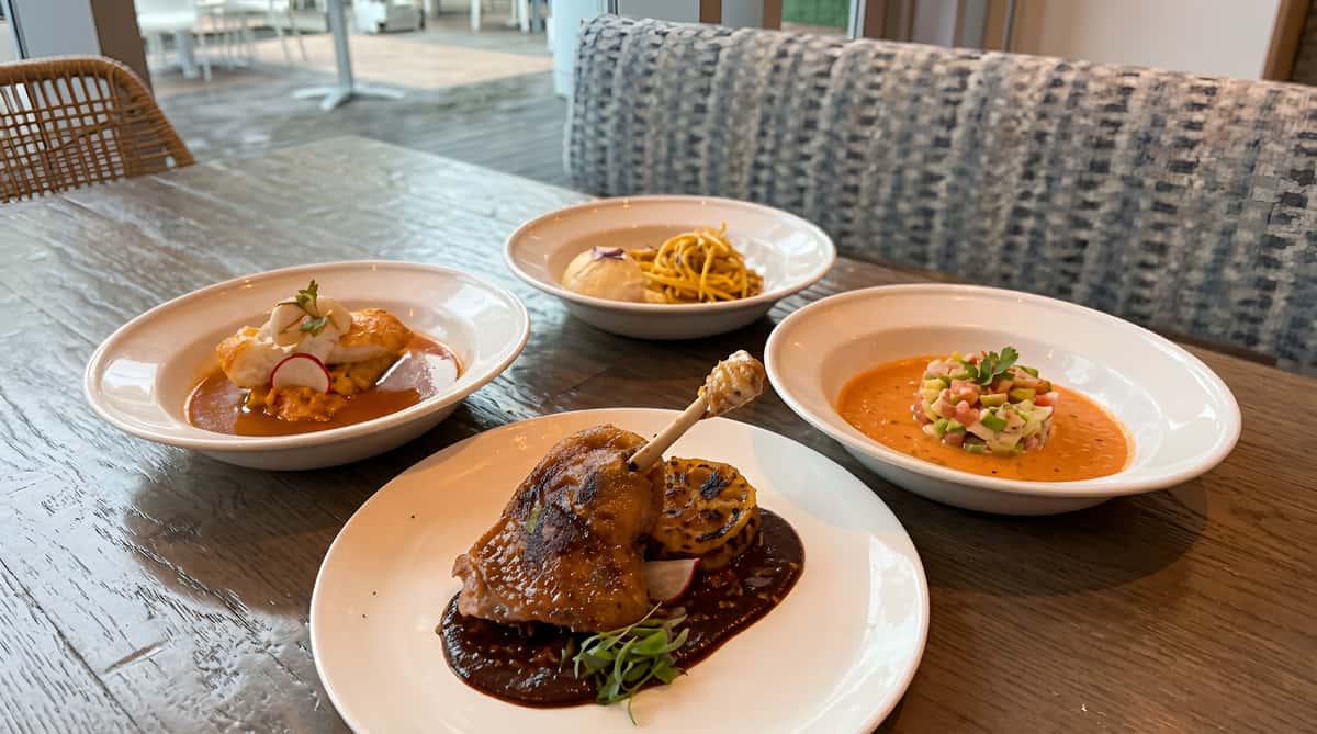 Four dishes: roasted duck confit, red snapper with broth, yellow pasta, and ceviche on red sauce.