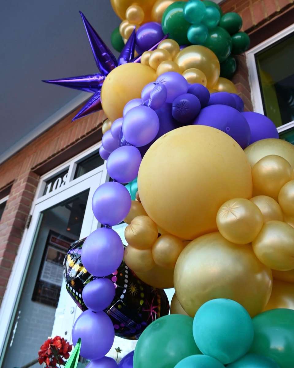 Lou Lou Food + Drink (St. Matthews) storefront decorated for Mardi Gras