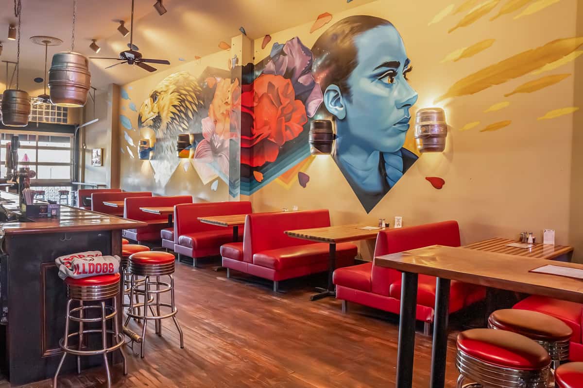 red booth seating beneath wall mural
