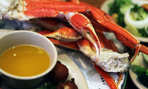 A plate of crab legs and a side of melted butter