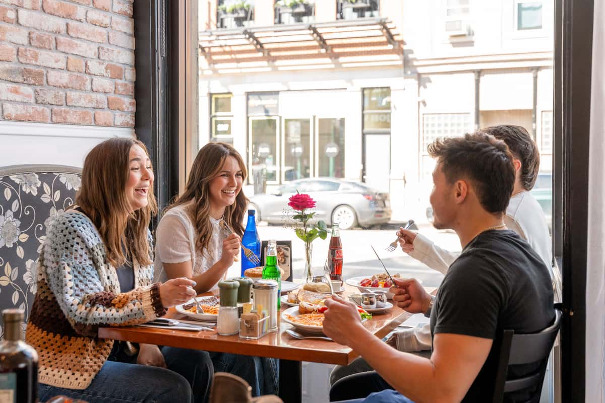 Friends sharing brunch at a window table at Lincoln Park Corner Kitchen