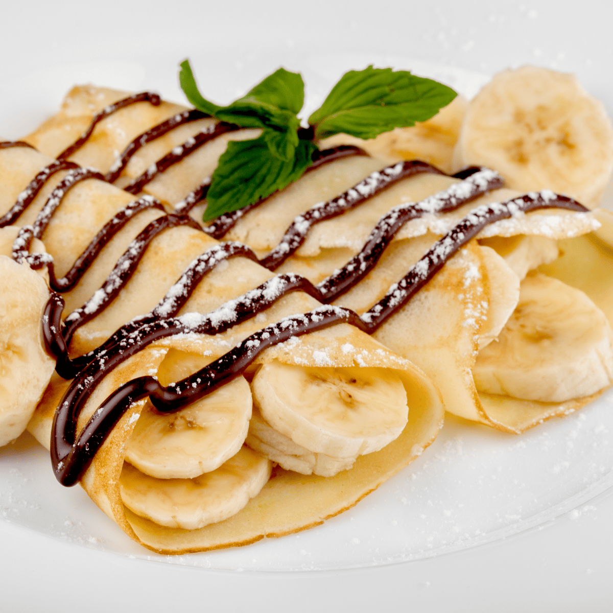 Nutella and sliced banana filled crepes, topped with even more bananas and powered sugar.