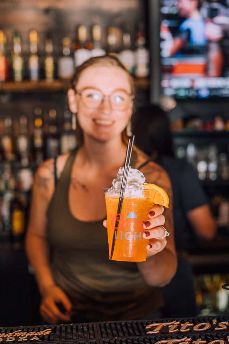 woman holding orange cocktail