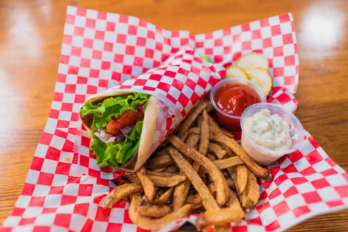 Tender sliced meat wrapped with crisp lettuce and fresh tomato, served alongside seasoned fries with creamy house-made dipping sauce and ketchup. A classic bar-and-grill favorite packed with flavor.