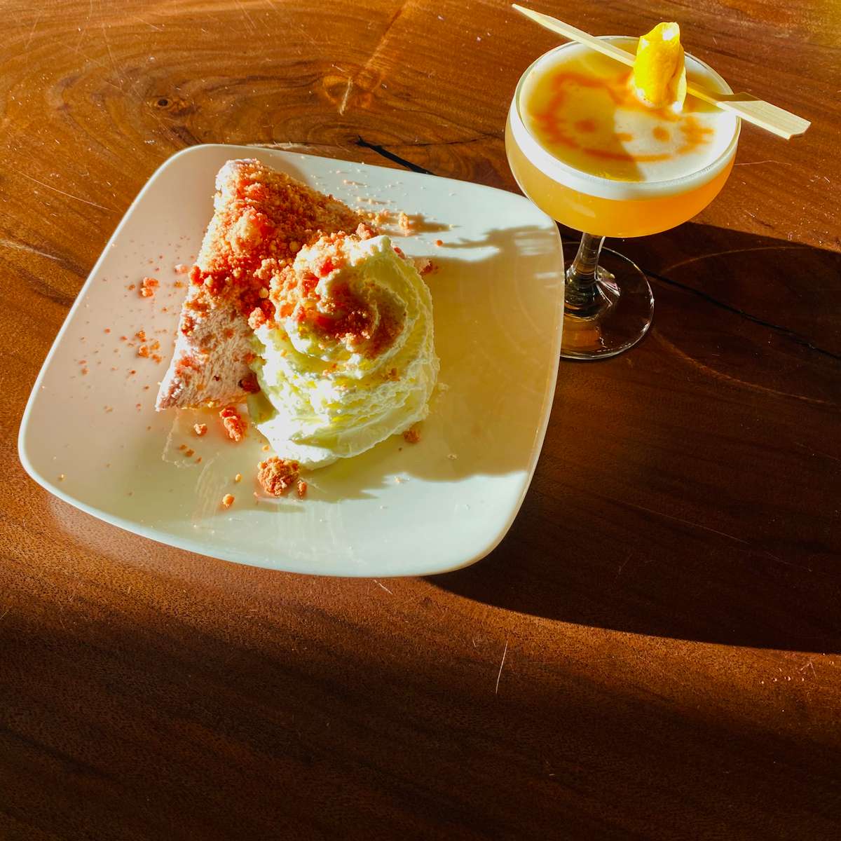 Image Description: Our new pie, The Burn Book, served alongside a whiskey sour which is garnished with a lemon peel.