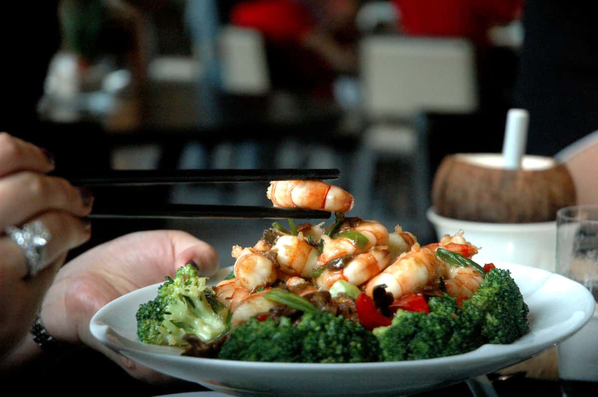 Hand holding a shrimp with Chopsticks