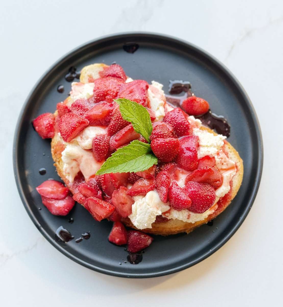 fresh strawberries roasted and topping a spread of mascarpone all perched on a stoneground fermented sourdough toast