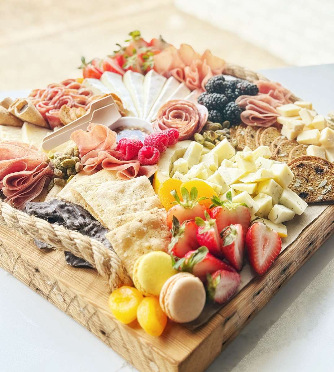 Curated selection of dried, cured Italian meats, artisanal cheeses, fruits, crackers and accoutrements