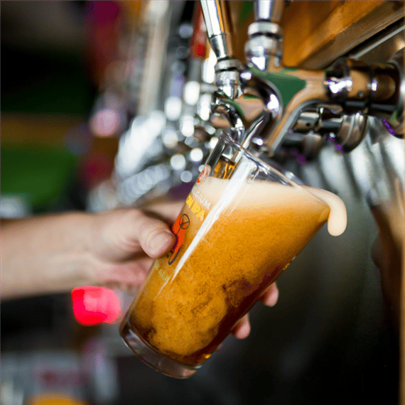 pint of beer being poured from tap into a glass