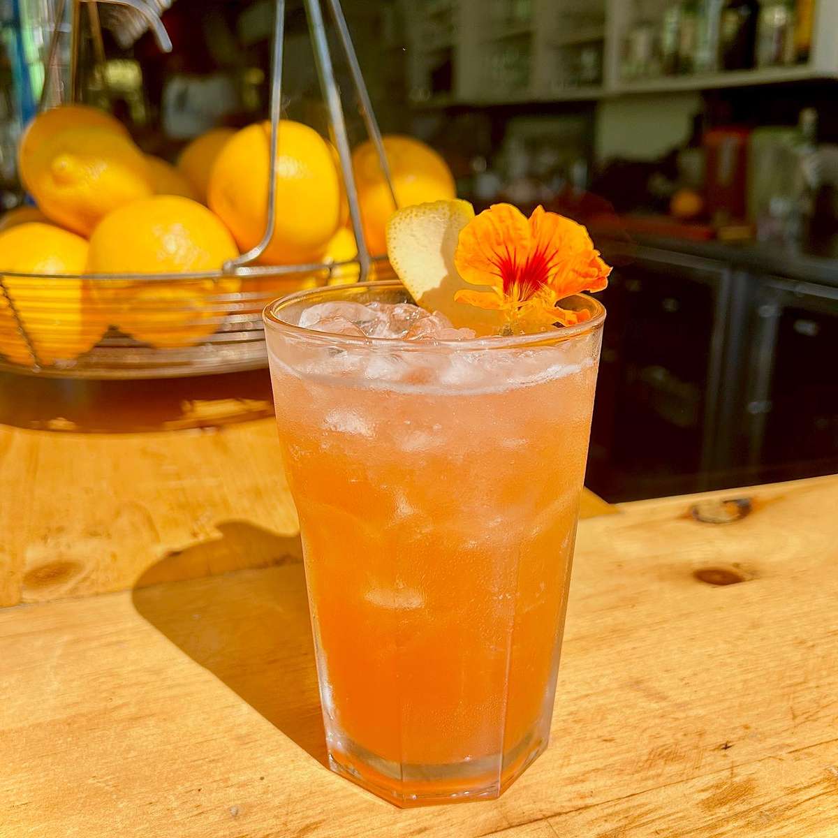 Bright colored cocktail garnished with a flower