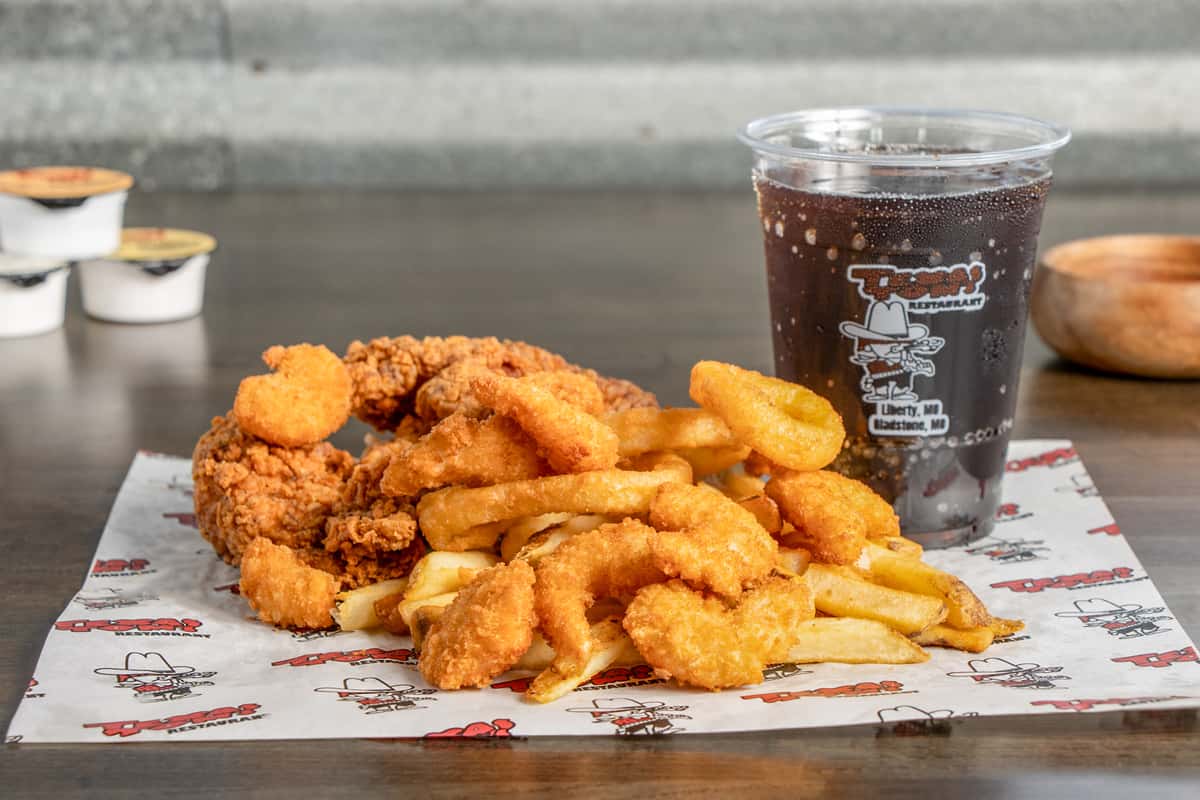 Texas Tom's crispy shrimp and chicken basket with seasoned fries and a soft drink
