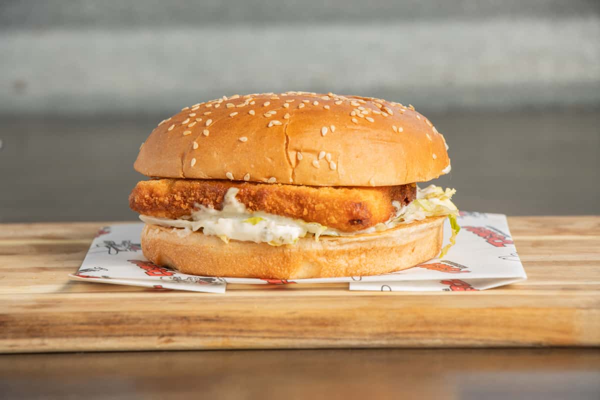 crispy fish fillet sandwich with lettuce on a toasted sesame seed bun