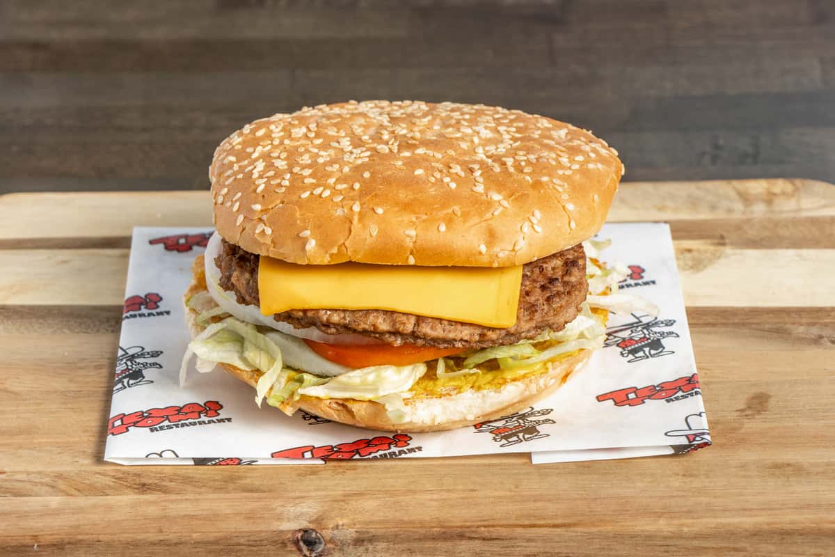 Texas Tom's double cheeseburger with two beef patties, melted cheese, onions, lettuce, and tomato on a sesame seed bun