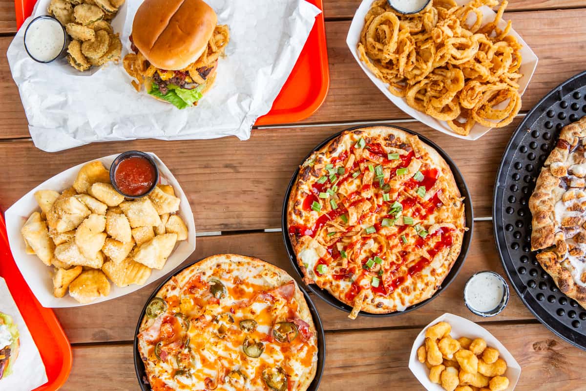 Spread of burgers, pizzas, fries, sides, and desserts from Jimmy's Burgers & Pizza in Hurst, TX