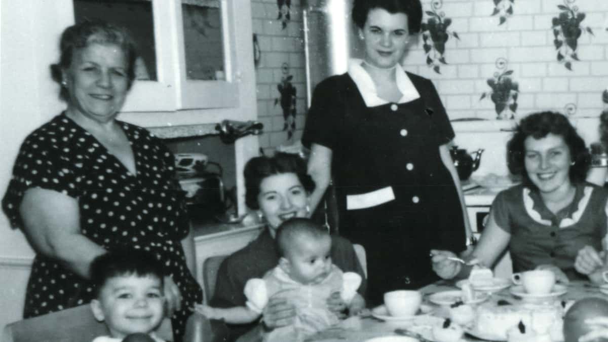 A young Maria sat at the table with friends and family