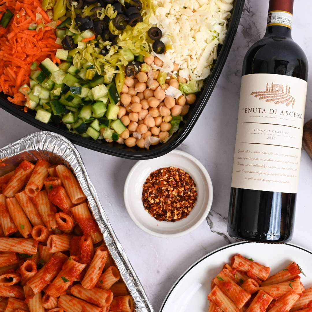 picture of a family meal with a bottle of wine.