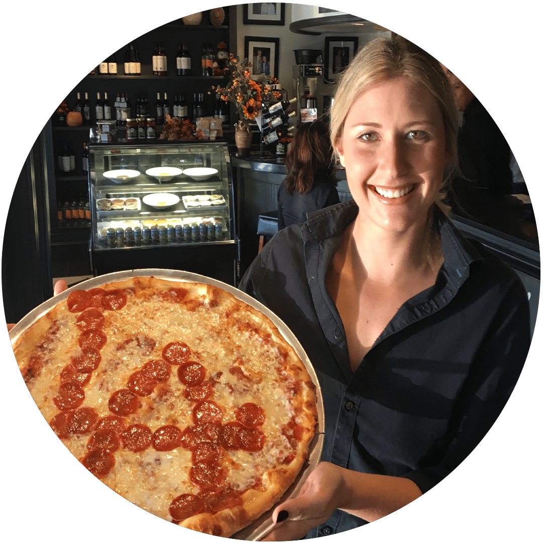 Smiling waitress holding a pizza that says LA in pepperoni