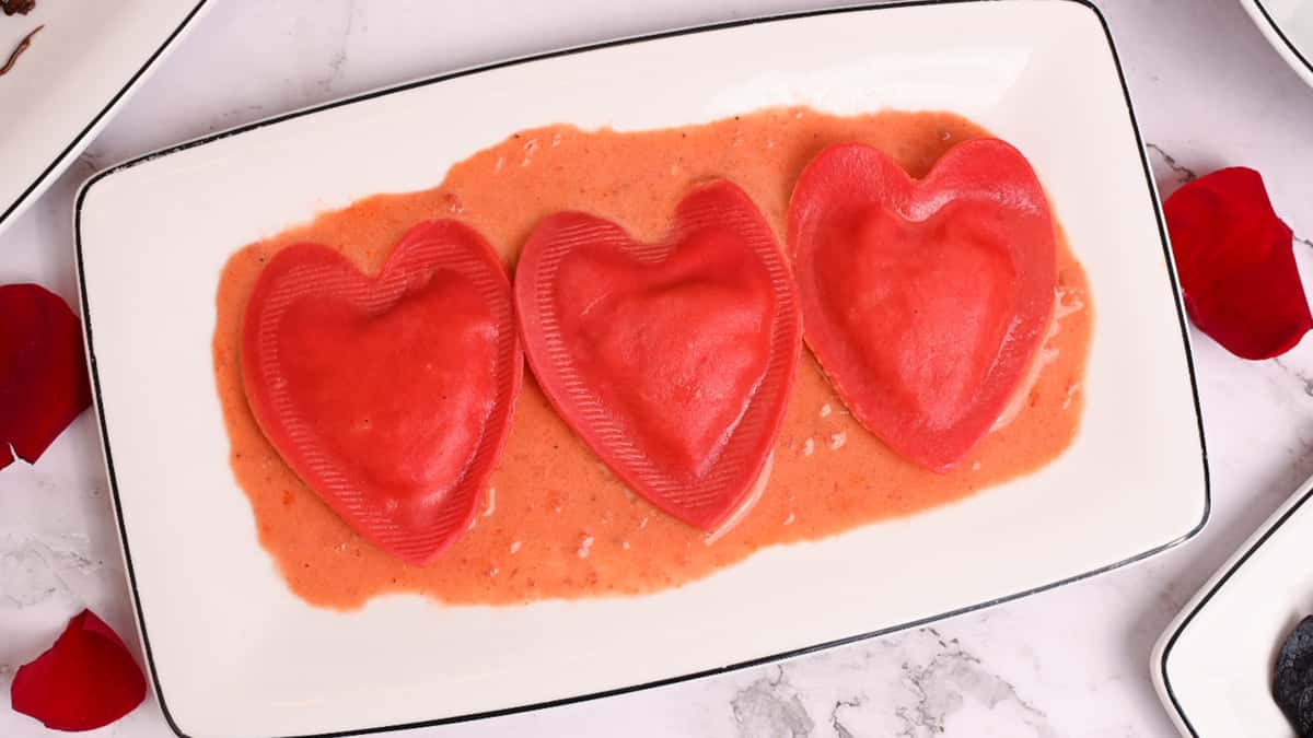 3 heart shaped ravioli on a plate