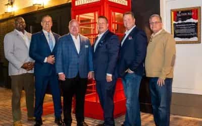 men in front of red phone booth