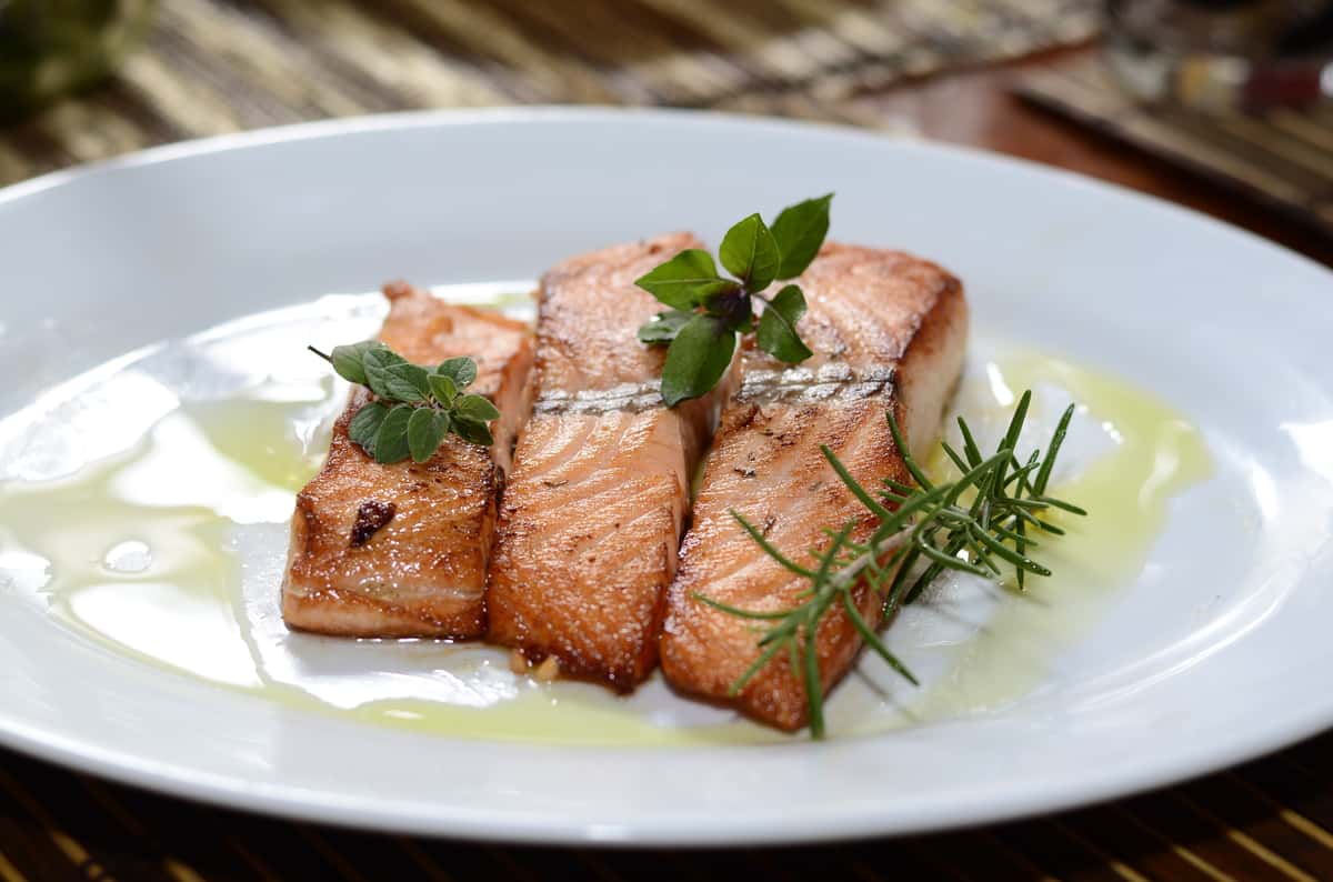 Grilled salmon fillet plated with fresh herb garnish