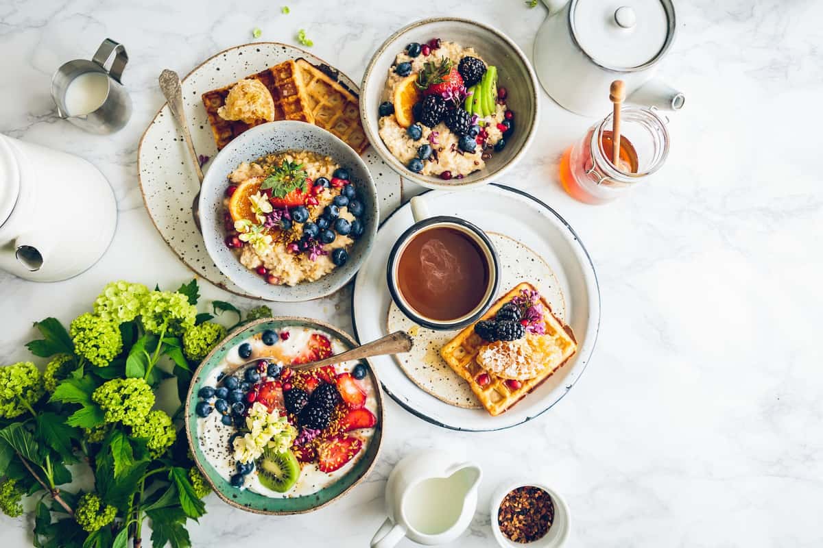 Overhead view of an assorted spread of toast, berries, and dips on a table