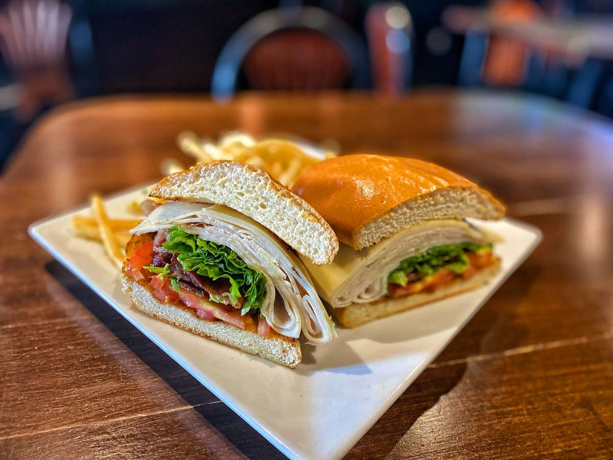 Meat sliced sanwiches with a side of fries