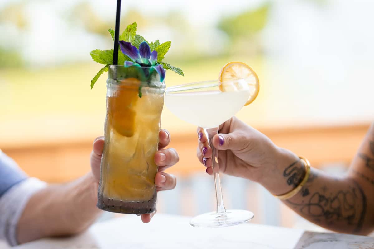 Two hands cheering cocktails