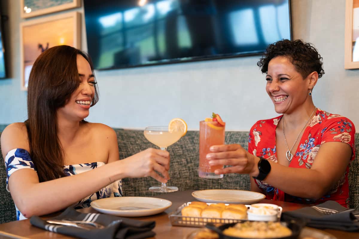 Two women cheering drinks