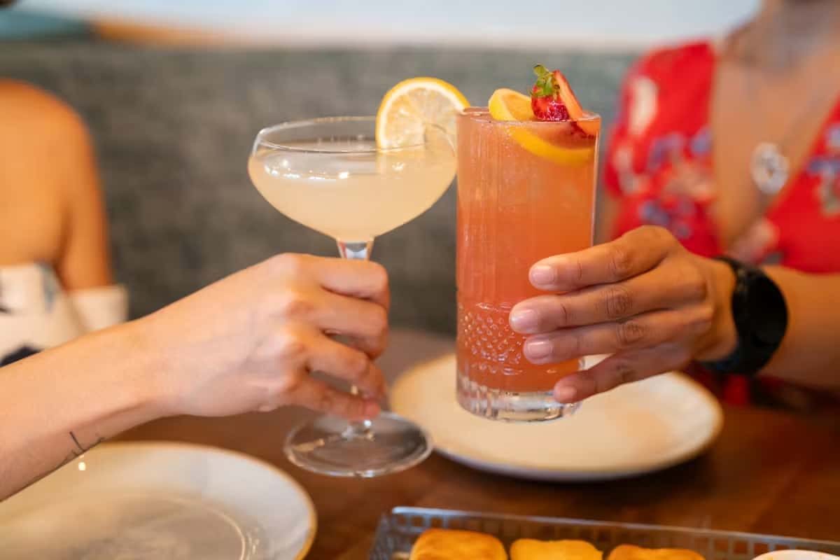 Hands cheering cocktail glasses