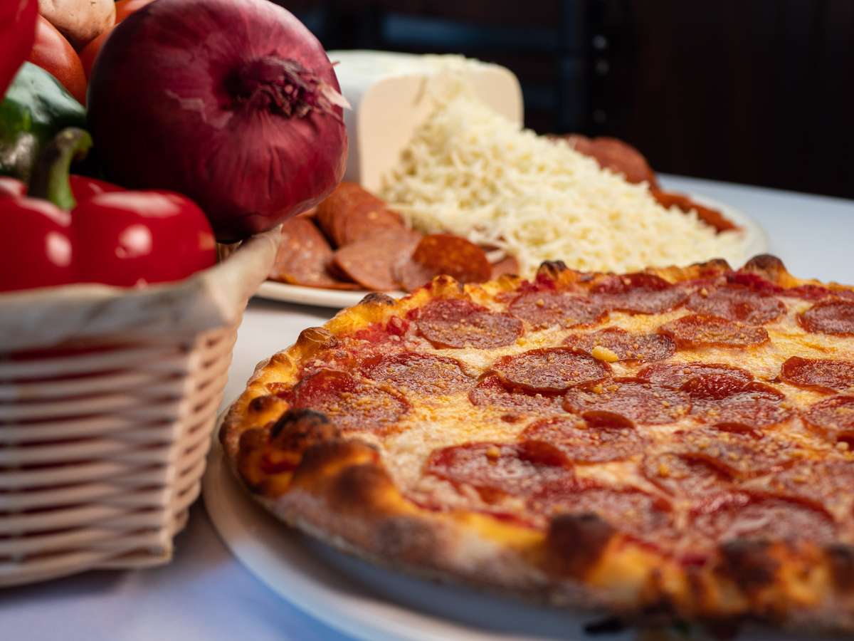 Pepperoni Pizza with the ingredients used to make it on the side