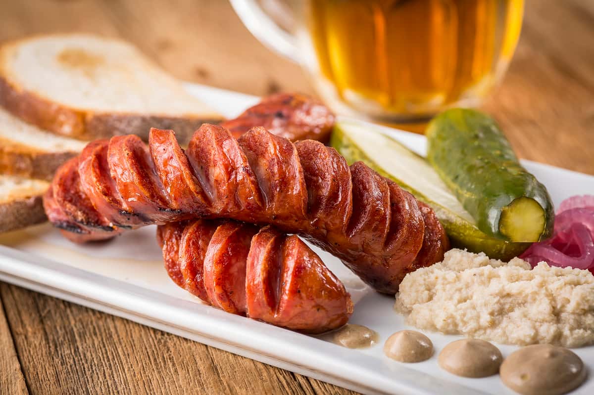 Sliced sausages plated with a side of rice and a drink
