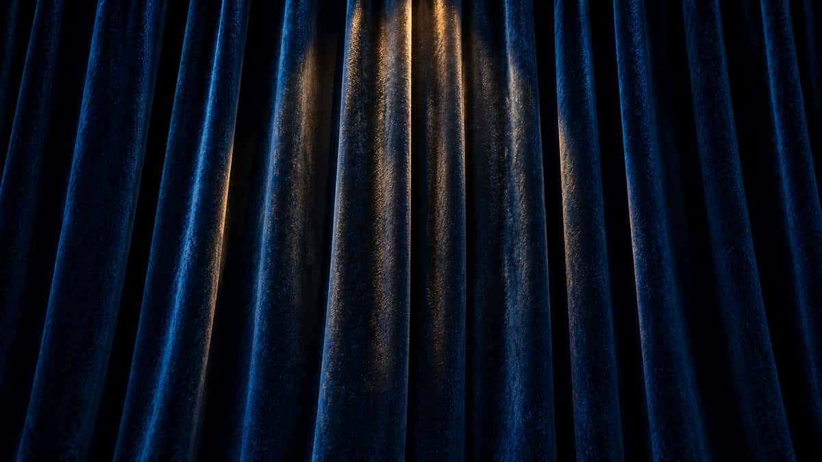 Blue velvet curtain under warm spotlight
