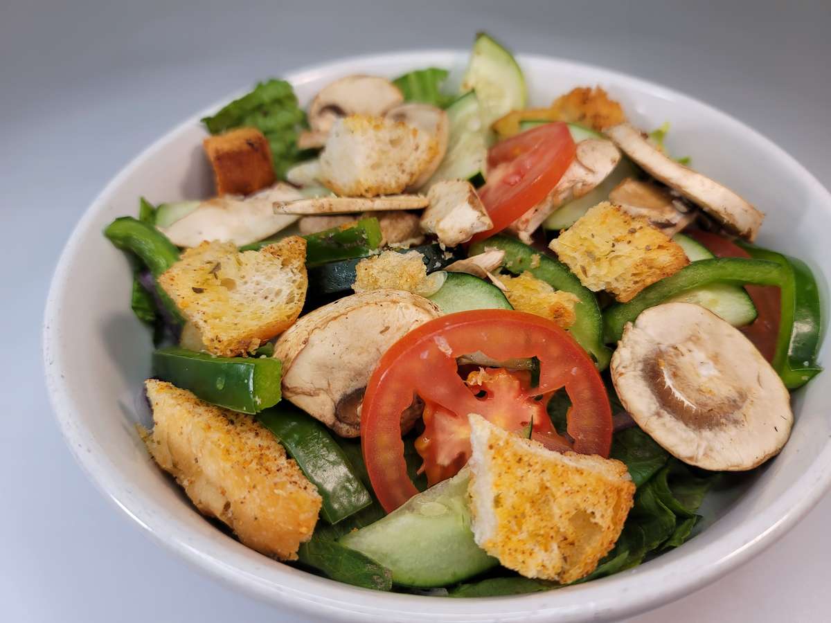 Gasparilla's colorful mixed salad featuring fresh greens, tomatoes, cucumber, mushrooms, peppers, and croutons at Gasparilla