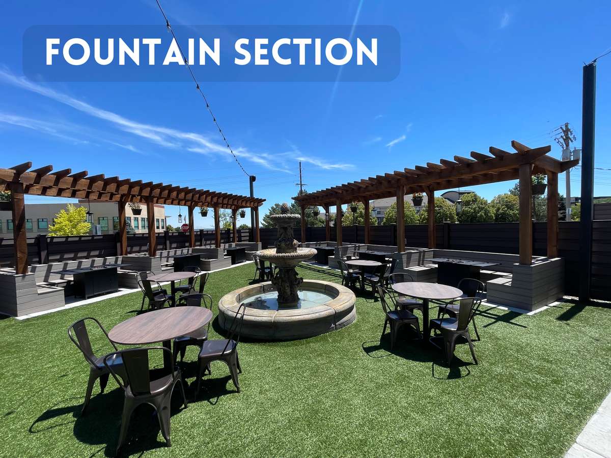 Outdoor patio fountain courtyard featuring pergola-covered lounge seating, open-air dining tables, and a relaxed atmosphere for private events and social gatherings.
