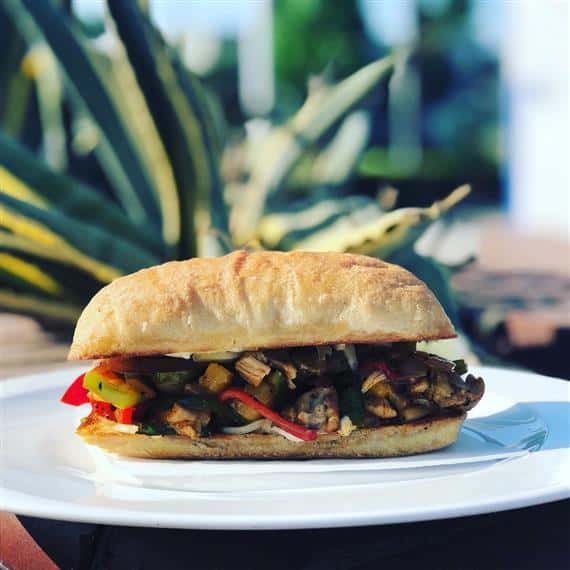 Caribbean chicken sandwich with bell peppers and pineapple salsa and mango-habanero rum sauce