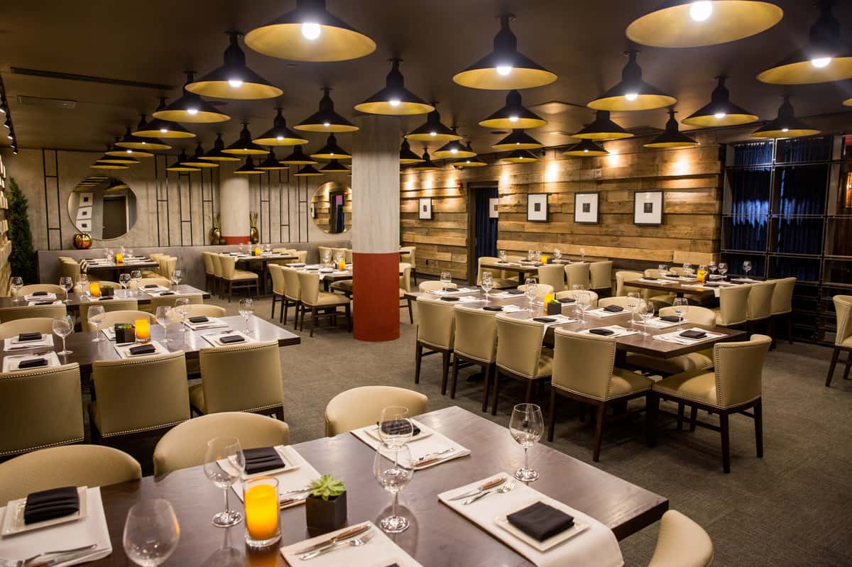 Mishima room event space at Kayne Prime with rustic wood walls, ambient lighting, and plush seating around large tables.