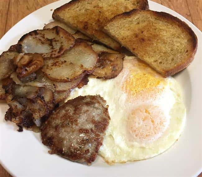 toast, eggs, sliced potatoes and sausage on a plate