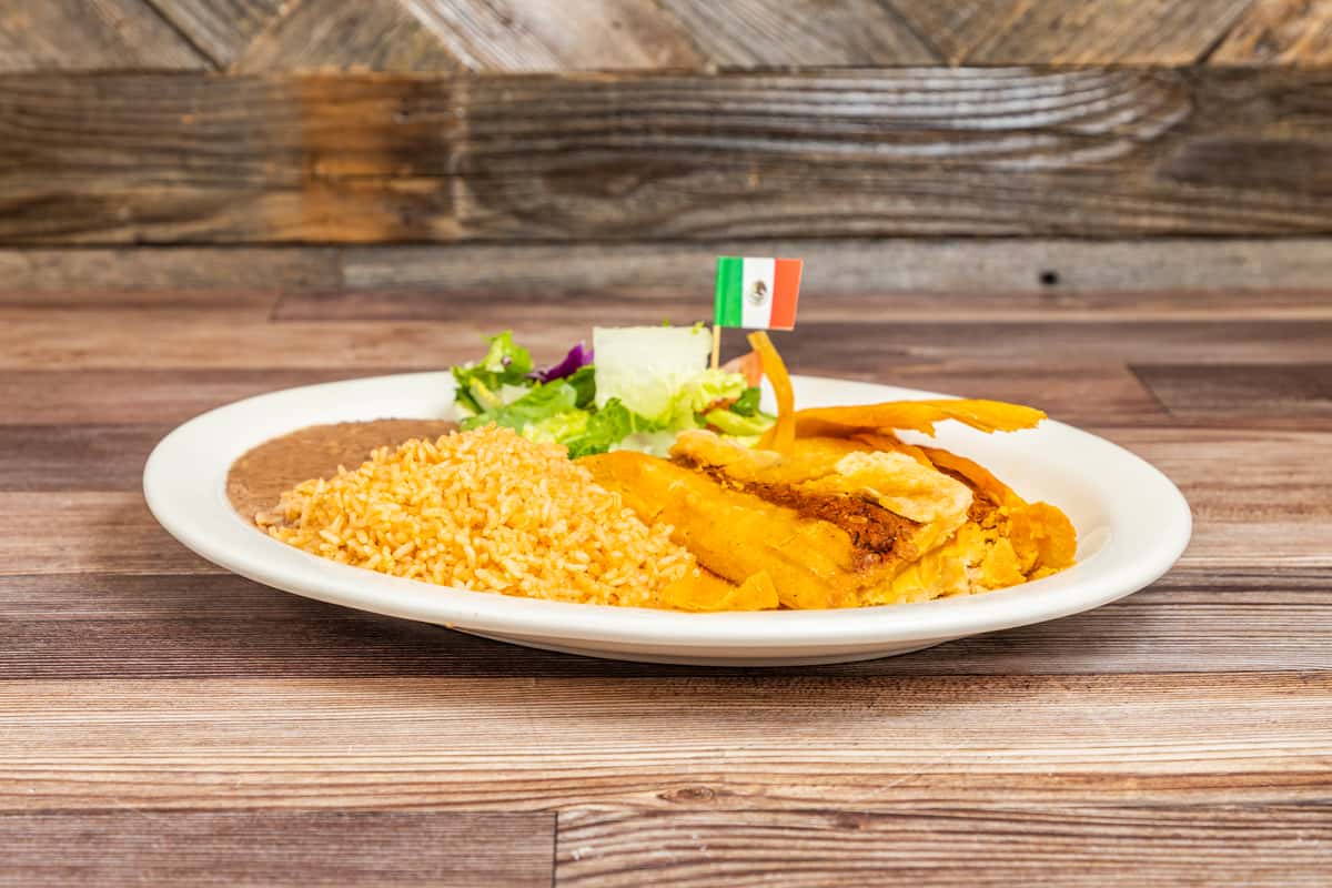 Traditional tamale entrée served with Mexican rice, beans, and fresh garnish