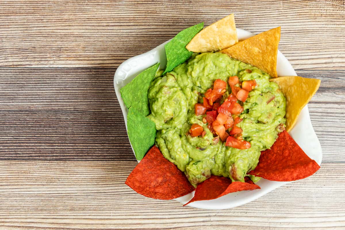 Fresh guacamole topped with pico de gallo and served with colorful tortilla chips at Maria's Mexican Grill