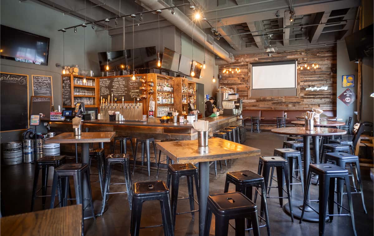 Warm and inviting private event space at Hardwood Bar & Smokery with communal seating, Bay Area hospitality, and modern industrial decor