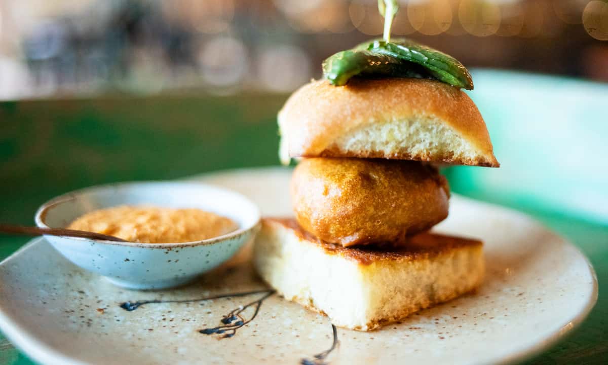 Spiced potato patty served in a soft Pao buttered bun, peanut sesame chutney (contains nuts).