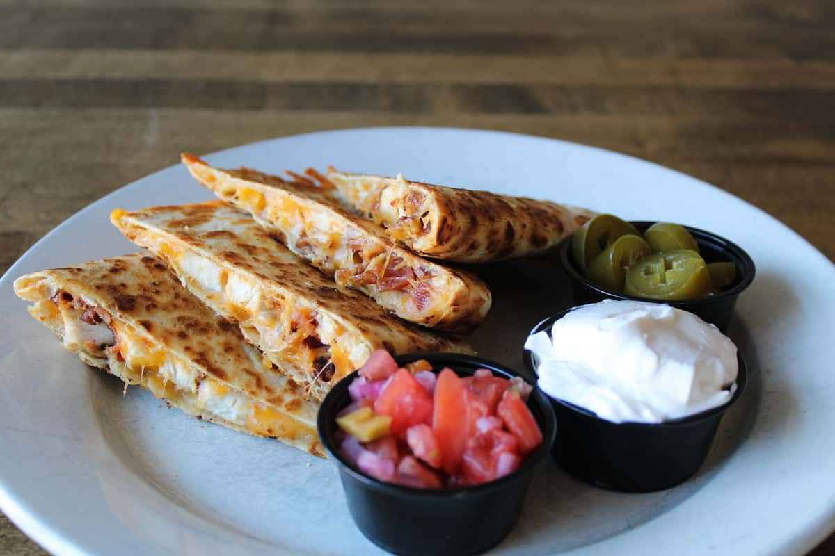 Our large flour tortilla stuffed with melted Jack & cheddar cheese, grilled chicken and crisp bacon crumbles. Served with pico de gallo, sour cream and jalapenos on the side