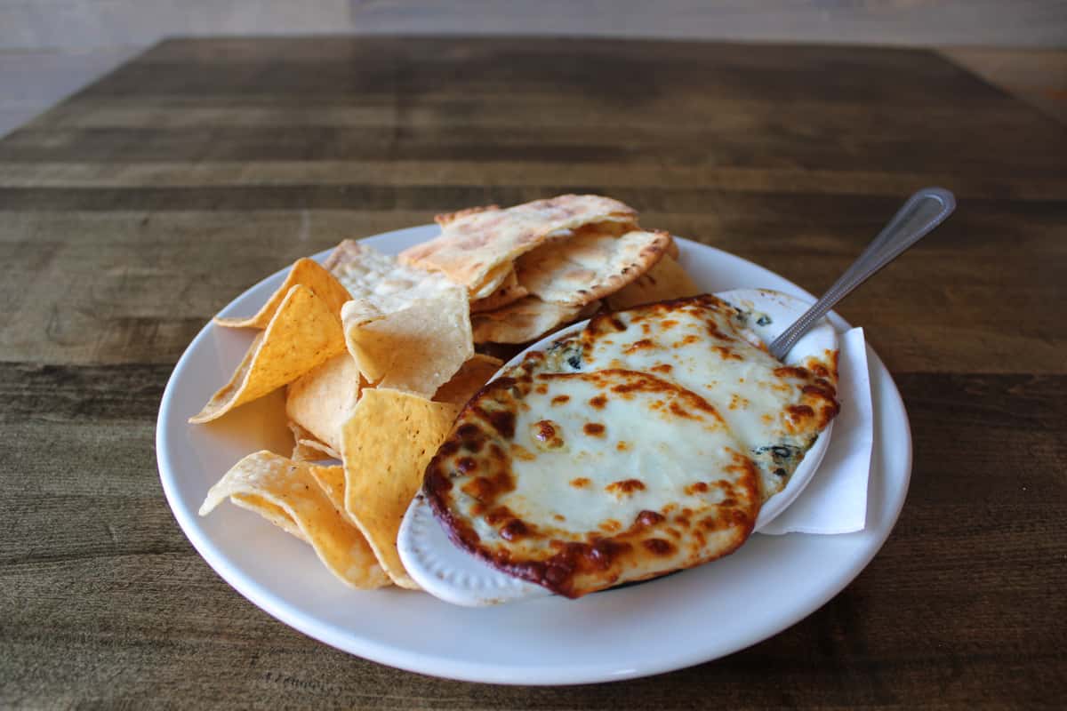 Baked creamy mix of cheeses, spinach & artichoke hearts served with white corn chips and garlic flatbread